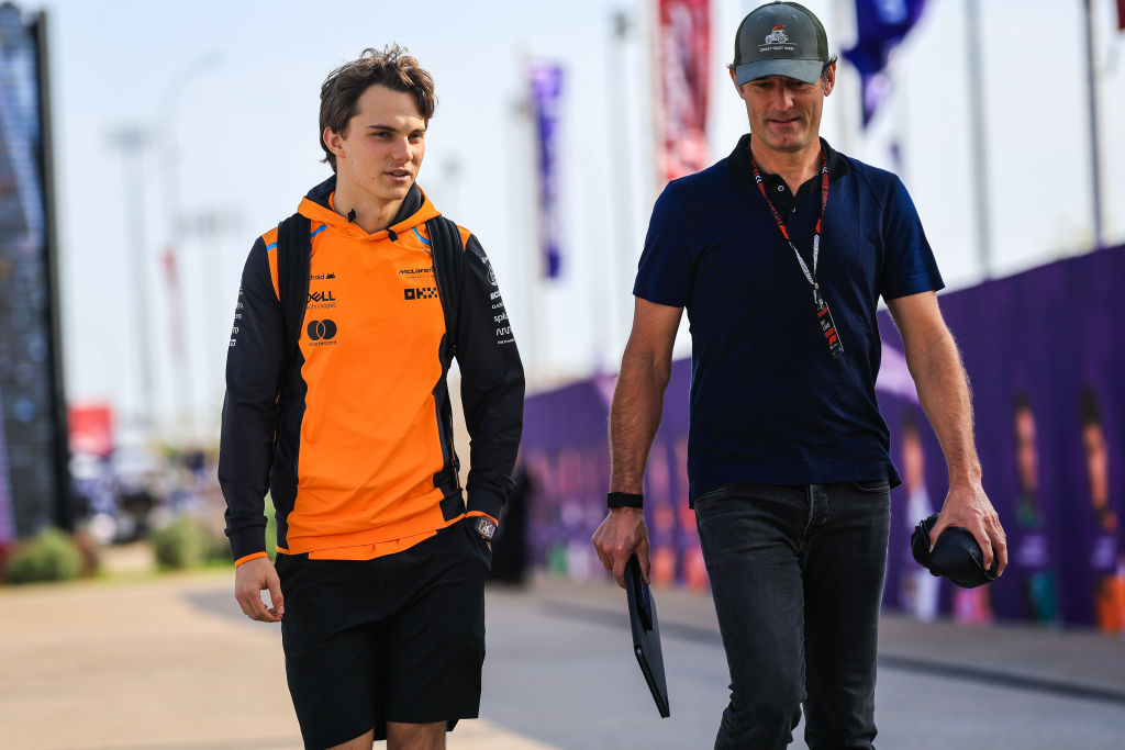 Oscar Piastri camina junto a Mark Webber por el paddock