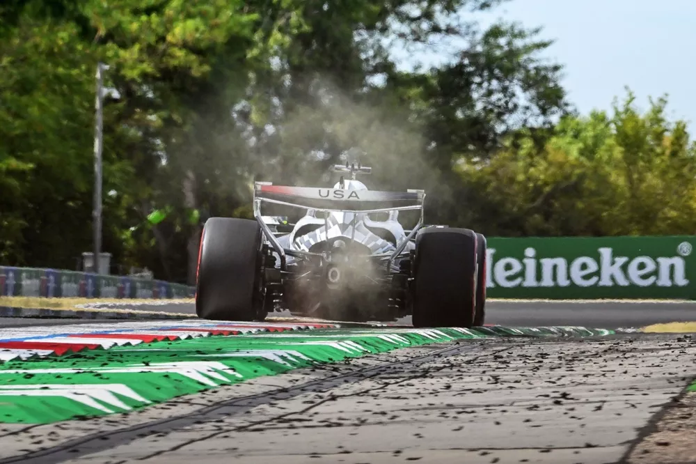 Monoplaza de Cadillac con el rótulo USA en el alerón trasero levantando polvo junto a los pianos del Hungaroring