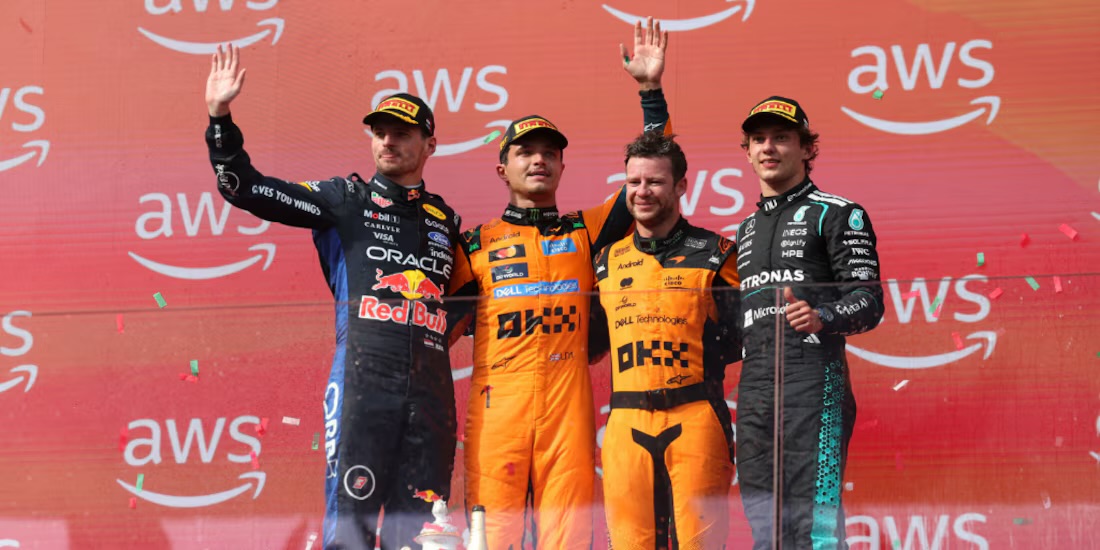 Podio del GP de Hungría 2026 en el Hungaroring, con Max Verstappen, Lando Norris y Kimi Antonelli celebrando junto a un miembro del equipo McLaren