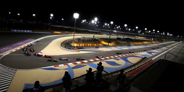 Vista amplia de la salida nocturna en el Bahrain International Circuit con los monoplazas tomando la primera curva