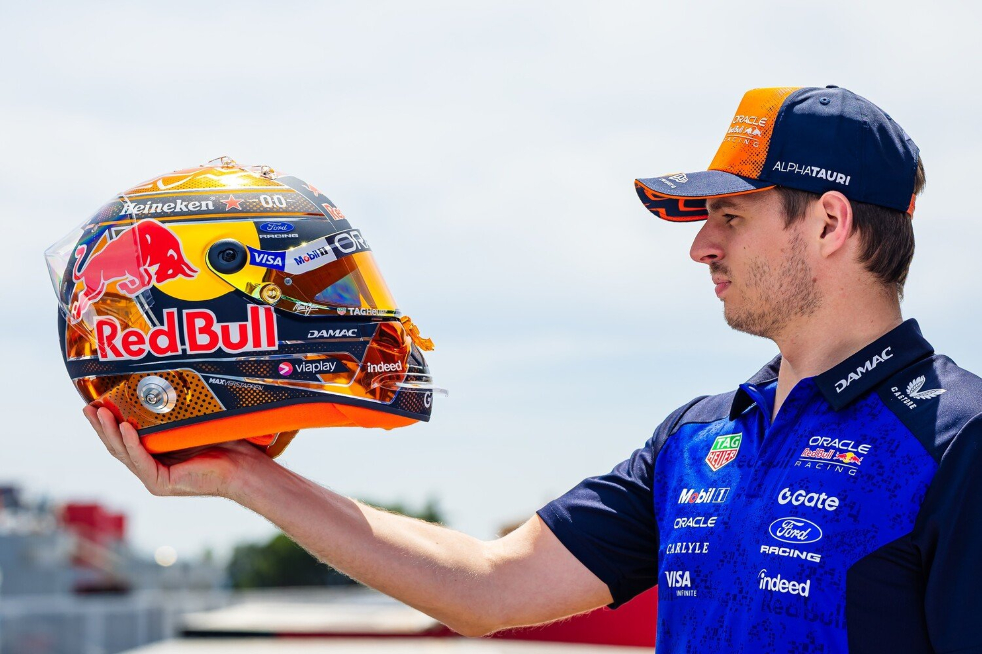 Max Verstappen sostiene su casco de Red Bull en el paddock durante un evento de equipo